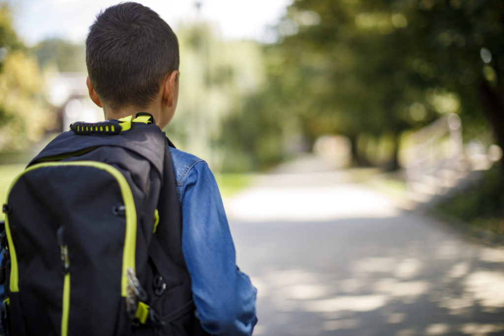 Teenage boy with school bag walking to school