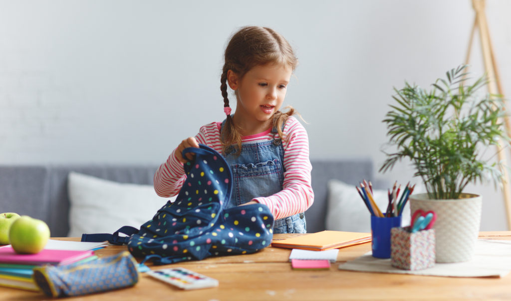 Girl packing her backpack for school